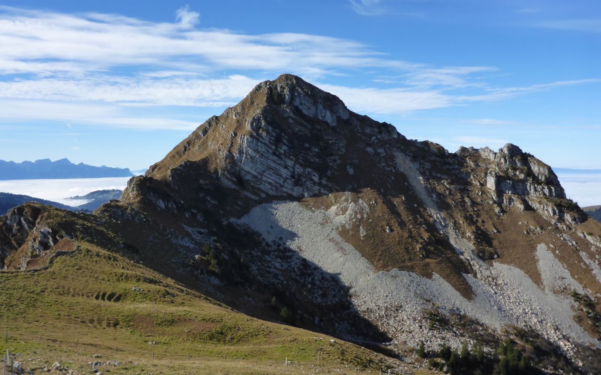 Sommet rocheux alpin, mer de nuages